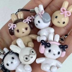 a person is holding several small key chains in their hand, some are wearing bunny ears