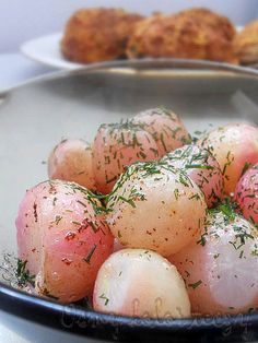 a bowl filled with potatoes covered in seasoning and sprinkled with parsley