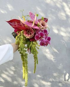 a person holding a bouquet of flowers in their hand