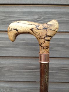 an old wooden walking stick with cracked paint on it