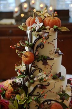 a wedding cake decorated with flowers and pumpkins