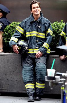 a fireman sitting on the side of a building