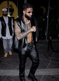 a man in black leather pants and tattoos