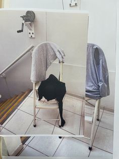 a chair that has been placed on the floor in front of a wall with a towel draped over it