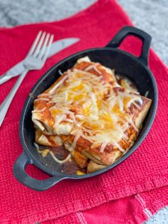 a cast iron skillet filled with cheesy bread and cheese on a red towel