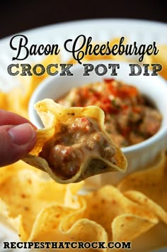 a hand holding up a cracker filled with cheeseburger crock pot dip