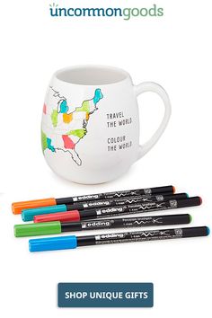 three markers and a mug with the words travel the world on it