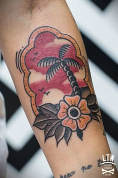 a tattoo on the arm of a person with a flower and palm tree in it