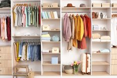 an organized closet with clothes, shoes and other items on shelves next to a chair