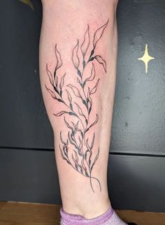 a woman's leg with a tattoo on it that has plants growing out of it