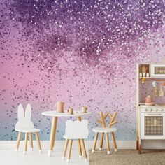 a room with purple and pink wallpaper, two chairs and a table in front of it