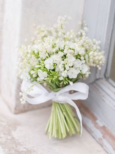 a bouquet of white flowers sitting on top of a window sill next to a door