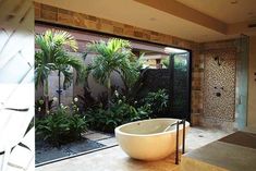 a large bath tub sitting in the middle of a bathroom next to a walk in shower