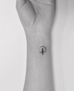 a woman's wrist with a small bird tattoo on the left side of her arm