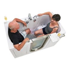 an older man and woman sitting in a bathtub