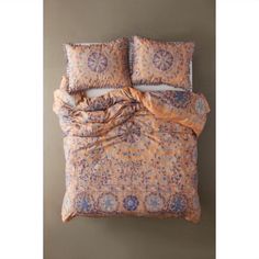 an orange and blue comforter with two pillows