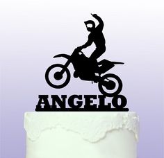 a cake topper that says angelo on it with a motorcycle rider in the middle