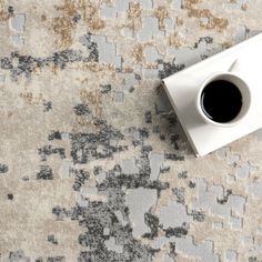 a cup of coffee sitting on top of a rug