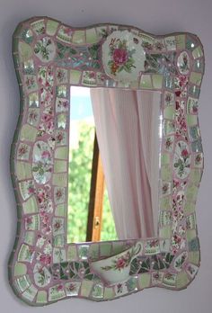 a pink and green mirror hanging on the wall