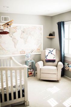 a baby's room with a crib, rocking chair and map on the wall