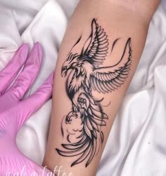 a woman's arm with a bird tattoo on it