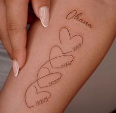 a woman's leg with three hearts and the names of her loved ones on it