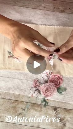 two hands are touching each other on a piece of fabric with flowers and leaves painted on it