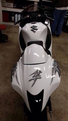 a white and black motorcycle parked in a garage