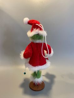 a red and white stuffed animal wearing a santa claus hat with earphones on it's head