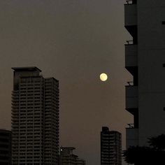 the sun is setting behind tall buildings in an area with high rise buildings and balconies