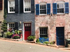 two brick buildings with blue shutters and red doors