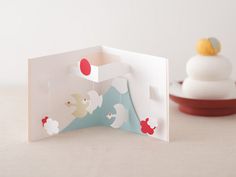 an open card with ducks on it next to a plate and cupcake in the background