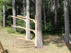 a wooden swing in the middle of a forest