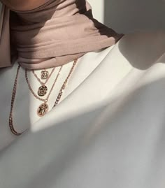 a close up shot of a woman's shirt and necklaces