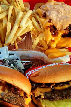 two cheeseburgers and french fries on a tray