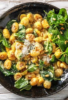 a black bowl filled with spinach and chickpeas