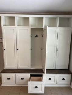 an empty room with some white cabinets and drawers in it's center area,