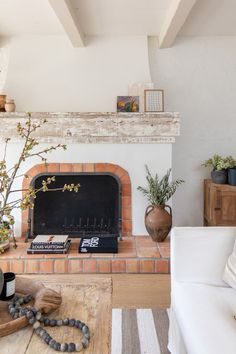 a living room filled with furniture and a fire place in front of a brick fireplace