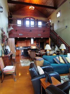 a living room filled with lots of furniture next to a stair case in a house