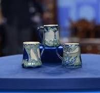 three mugs sitting on top of a blue table