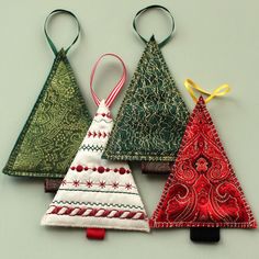 three christmas tree ornaments hanging on hooks