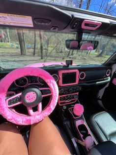 a pink steering wheel cover sitting on the inside of a car's dash board