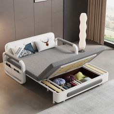 a bed with an open drawer underneath it in a room next to a large window