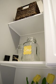 some jars are sitting on top of the shelves