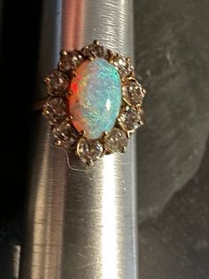 14k Antique ring-Australian Fiery Opal and Old European cut Diamonds.  Condition is good any wear commensurate with age-photos show the details.  SIZE 5, Wt.- 3.1 grams, 5/8" north to south on finger.  Lovely inner red glow mainly blues and green color changes with movement, the old European cut Diamonds are approx 3mm each and there are 10 Diamonds they have a bit of color to them and work perfectly as a framing gallery for the oval 10 by 7mm Opal, all stones prong set.  A Lovely Antique early 1900s ring. 1900s Ring, Vintage Opal Ring, Opal Ring Vintage, Age Photos, Diamond Frame, Antique Ring, Vintage Keys, European Cut Diamonds, Natural Opal