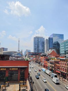 a city street filled with lots of traffic and tall buildings next to eachother