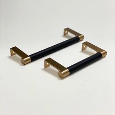 two black and gold handles on a white surface