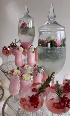 there are many glasses with drinks in them on the table and one is filled with flowers