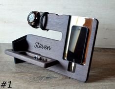 a cell phone and pen holder on a wooden surface with the name steven written on it