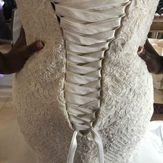 the back of a wedding dress being worked on